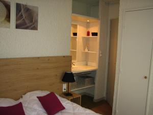 a bedroom with a bed and a desk in it at VVF Bourgogne Auxois Morvan in Semur-en-Auxois