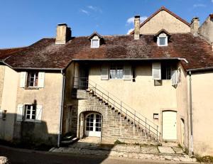 an old brick house with a staircase in front of it at Chambre 2 personnes Maison Saint Jean in Château-Chalon