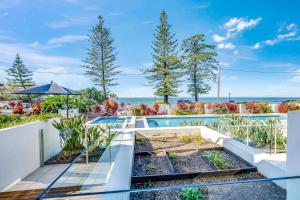 a swimming pool with a garden in a house at C Bargara Unit 101 in Bargara