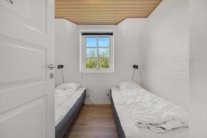 two beds in a room with a window at Feriehus 2033 in Ulfborg +32 photos