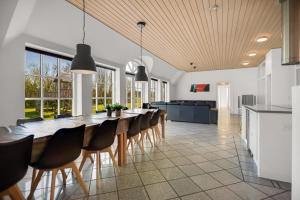a large dining room with a long table and chairs at Feriehus 2033 in Ulfborg