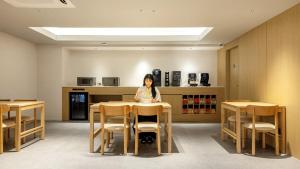 a woman sitting at a table in a room at Anook Hotel Ulsan Samsan in Ulsan