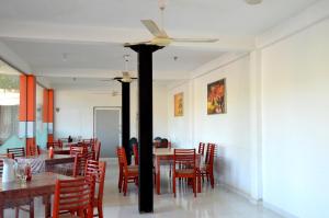 a dining room with tables and chairs and a ceiling fan at Cafe Pinnalanda in Pinnawala