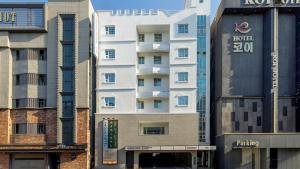 a white building in a city with tall buildings at Anook Hotel Ulsan Samsan in Ulsan