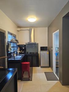 a kitchen with a refrigerator and a red chair at Balina-Blume in Kathu
