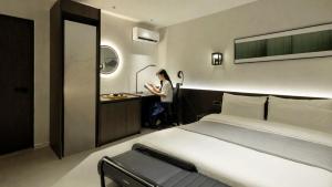 a woman standing in a hotel room with a bed at Anook Hotel Ulsan Samsan in Ulsan +165 photos