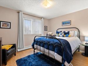 a bedroom with a bed and a blue rug at All About Alaska in Anchorage