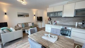 a kitchen and living room with a table and a couch at Strandbox & Strandresidenz in Norderney