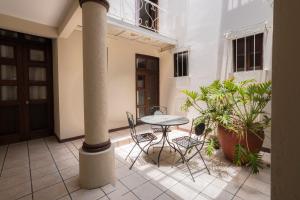 a patio with a table and chairs and plants at HOTEL NIUT-JA in Oaxaca City