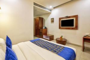 a hotel room with a bed and a tv at Hotel Royal Imporio Surajkund Faridabad in Faridabad