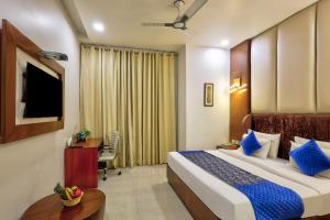a hotel room with a bed and a desk and a television at Hotel Royal Imporio Surajkund Faridabad in Faridabad +73 photos