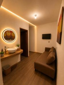a bathroom with a couch and a sink in a room at Hotel Bugambilia in Zimapán