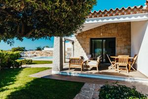a patio with chairs and a table in a house at VILLA INDIPENDENTE AL MARE BUDONI in Tanaunella