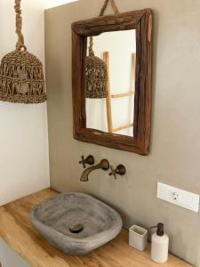 a bathroom with a stone sink and a mirror at Villa Olympia with private pool in Antiparos +24 photos