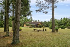 a park with a bench in front of a house at Peaceful Holiday Home Close To Nature in Glesborg +14 photos