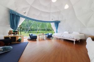 a bedroom with two beds and a large window at GRAMPING STAY TOMAMU in Tomamu