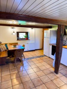 a kitchen and dining room with a table and refrigerator at Cottage des potiers in Niederbetschdorf