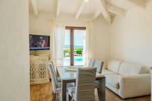 a living room with a couch and a table with chairs at VILLA INDIPENDENTE AL MARE BUDONI in Tanaunella
