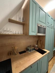 a kitchen with blue cabinets and a counter top at Apartmán - Ostrůvek 203 in Lesná