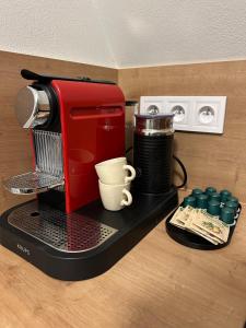 a red coffee maker and a cup on a counter at Apartmán - Ostrůvek 203 in Lesná +25 photos