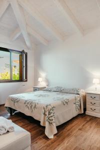 a white bedroom with a bed and a window at VILLA INDIPENDENTE AL MARE BUDONI in Tanaunella +19 photos