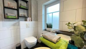 a bathroom with a toilet and a window at Strandbox & Strandresidenz in Norderney +61 photos