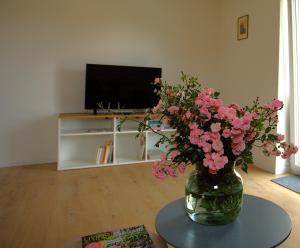 a vase with pink flowers on a table in a living room at Trüffelhof 2 in Bodman-Ludwigshafen