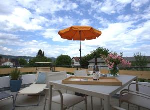a table and chairs with an umbrella on a balcony at Trüffelhof 2 in Bodman-Ludwigshafen