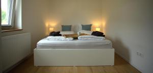 a white bed in a room with two bags on it at Trüffelhof 2 in Bodman-Ludwigshafen