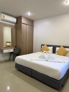 a bedroom with a bed with two swans on it at J2 Airport Mansion in Nai Yang Beach +25 photos