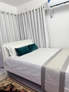 a white bed with two blue pillows in a room at Havene 11 in Dhaka