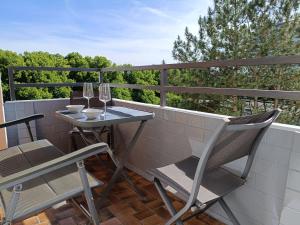 a small table and chairs on a balcony with trees at Westblick in Plön