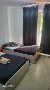 two beds sitting in a room with a window at Chambre Studio Bas Prix in Port Louis