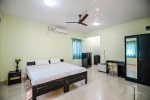 a bedroom with a bed and a ceiling fan at Sunshine Park Homes in Colva