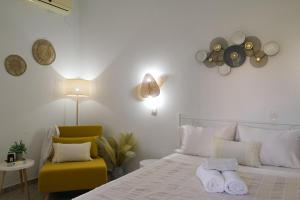 a bedroom with a bed and a yellow chair at Studios Margarita in Artemonas