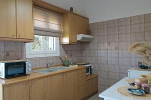 a kitchen with a sink and a microwave at Studios Margarita in Artemonas +23 photos