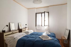 um quarto com uma cama azul com toalhas em Casa Gemei em Mello