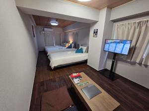 a room with two beds and a flat screen tv at KANDA HOUSE!! Shin-Okubo Walkable Modern Stay with Shinjuku Access in Tokyo