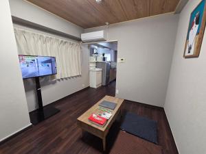 a living room with a flat screen tv and a table at KANDA HOUSE!! Shin-Okubo Walkable Modern Stay with Shinjuku Access in Tokyo +63 photos