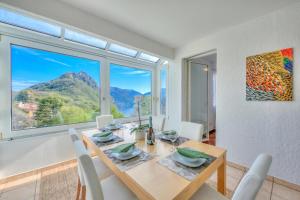 a dining room with a table and a large window at Residenza Parco Carona with Lake-View - Happy Rentals in Lugano