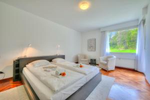 a large bed in a bedroom with a large window at Residenza Parco Carona with Lake-View - Happy Rentals in Lugano