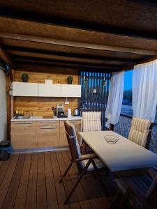 a kitchen with a table and chairs in a room at Mobile home Magdalena in Pirovac