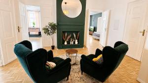 a living room with two chairs and a fireplace at Gera Apartment Green in Gera