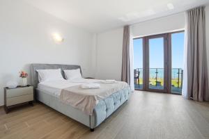 a bedroom with a large bed and a large window at InWaves in Vama Veche