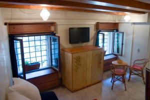 ein Wohnzimmer mit einem TV und 2 Fenstern in der Unterkunft Casa Carlo Goldoni in Venedig