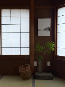 a vase with a plant in a room with windows at 一組限定の宿 季の間 Private Traditional House & Tea Experience in Nagano in Iida +67 photos