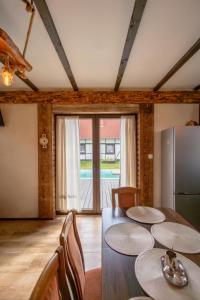 a dining room with a table and a refrigerator at Klinwdzydze in Wdzydze Tucholskie +9 photos