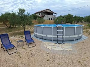 a hot tub with two chairs and a ladder in front at Mobile home Magdalena in Pirovac