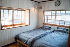 a bedroom with a bed and a clock on the wall at The Alpen House Omachi in Omachi