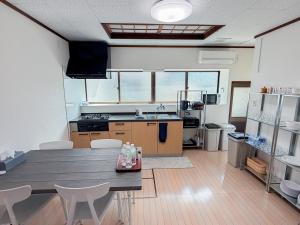 a kitchen with a table and chairs in a room at The Alpen House Omachi in Omachi